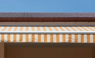 Store banne blanc et jaune sur une maison traditionnelle